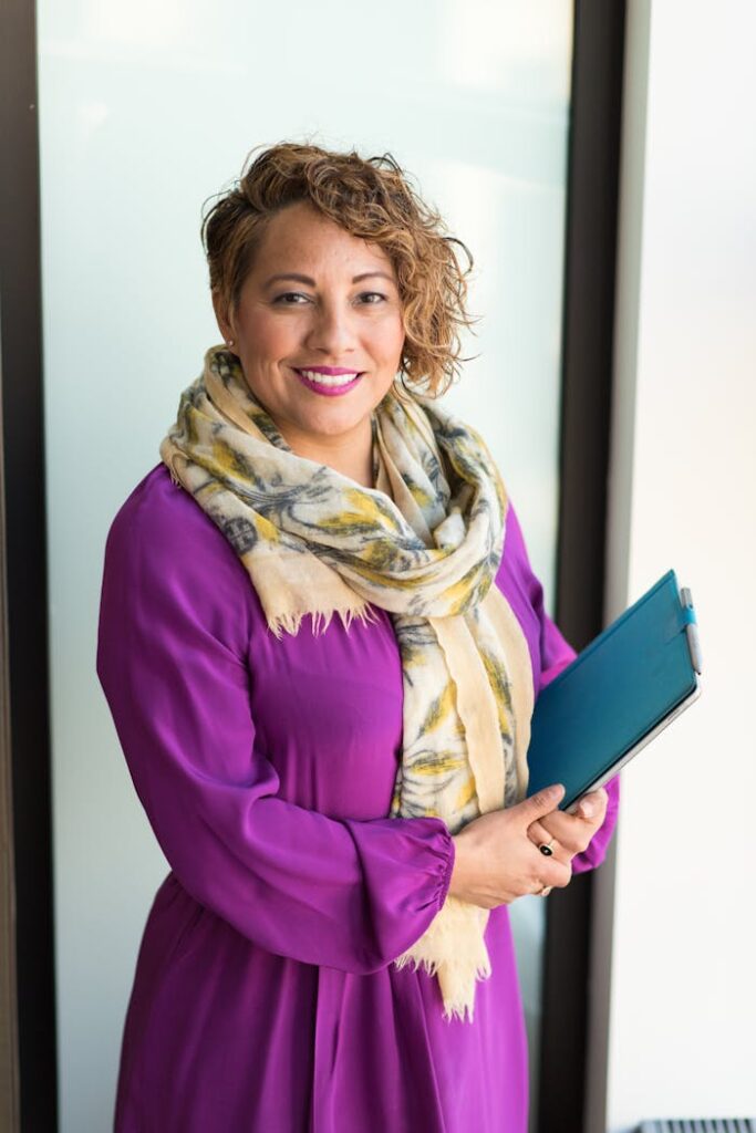 pexels-photo-1181424 Woman Smiling and Holding Teal Book